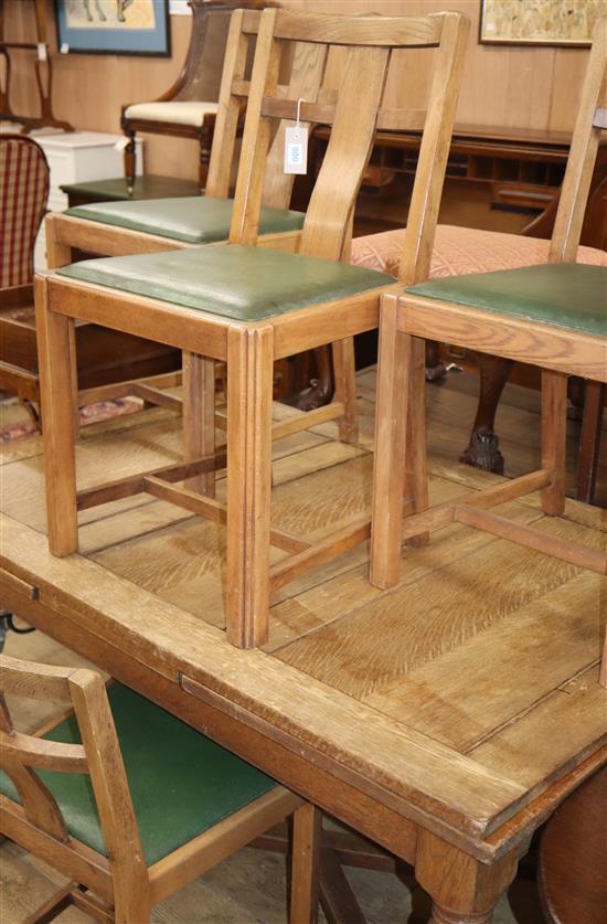 A 1930s oak draw leaf table and four chairs (230cm. extended)